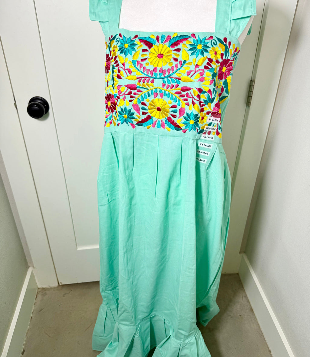 Colorful dress with floral pattern on a mannequin against a white door background