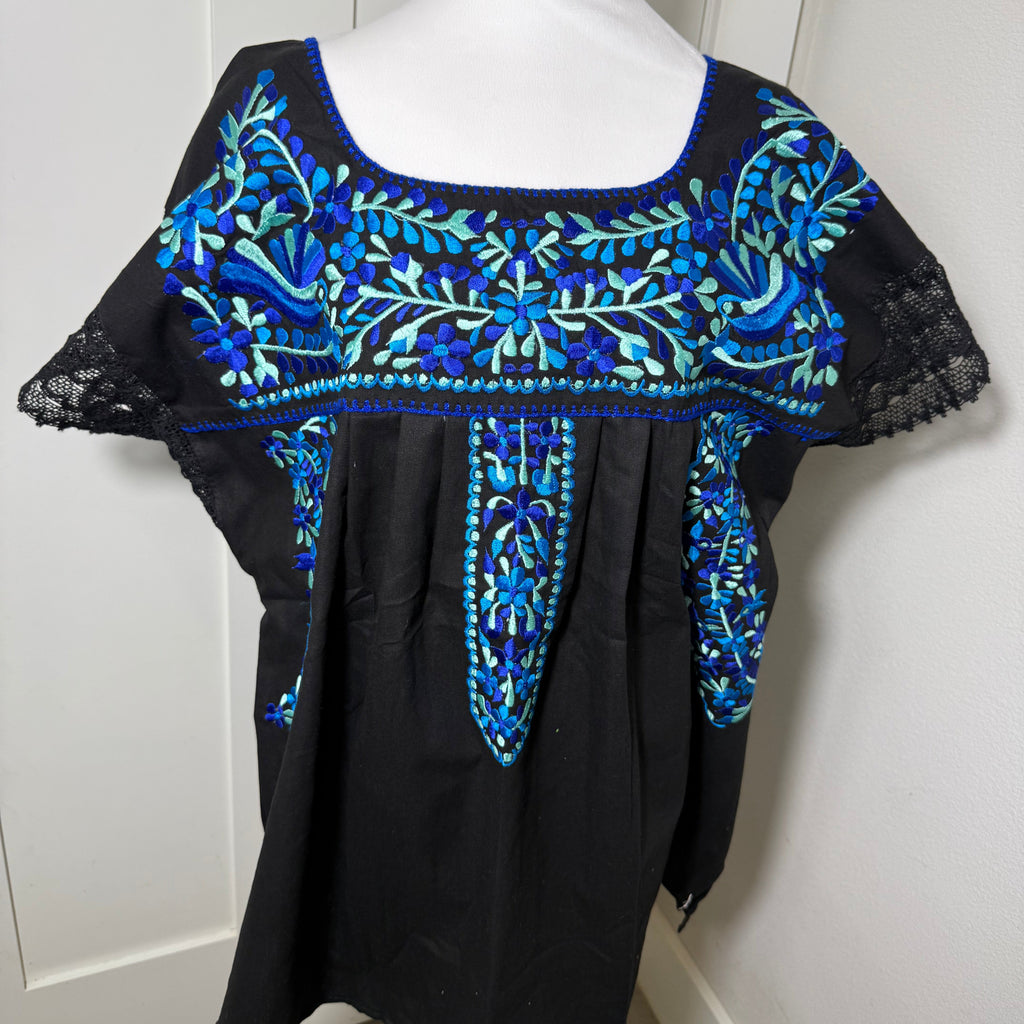 Black BLOUSE with blue floral embroidery on a mannequin against a white background